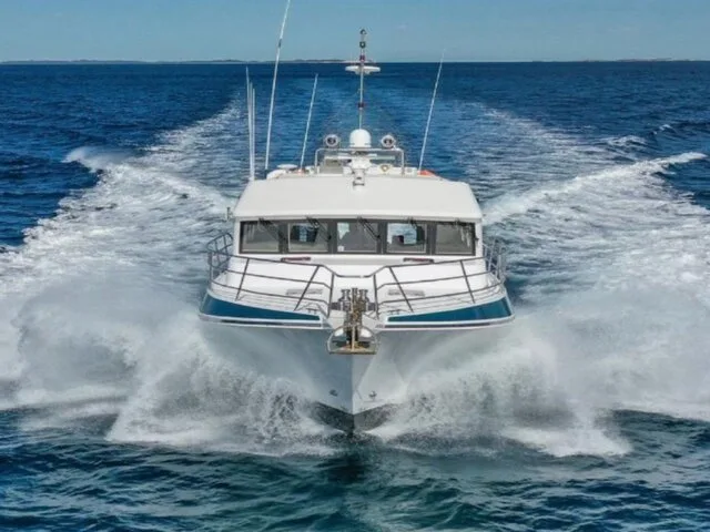 A sleek fishing boat cruising through clear blue waters, showcasing its powerful design and capabilities.