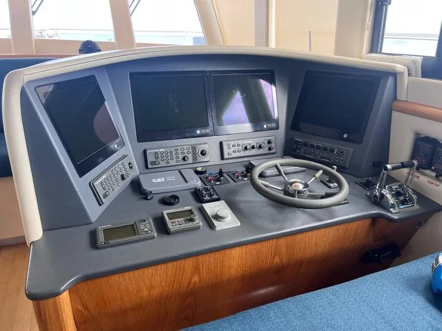 Interior view of a modern fishing boat's helm, showcasing advanced electronics and controls for navigation.